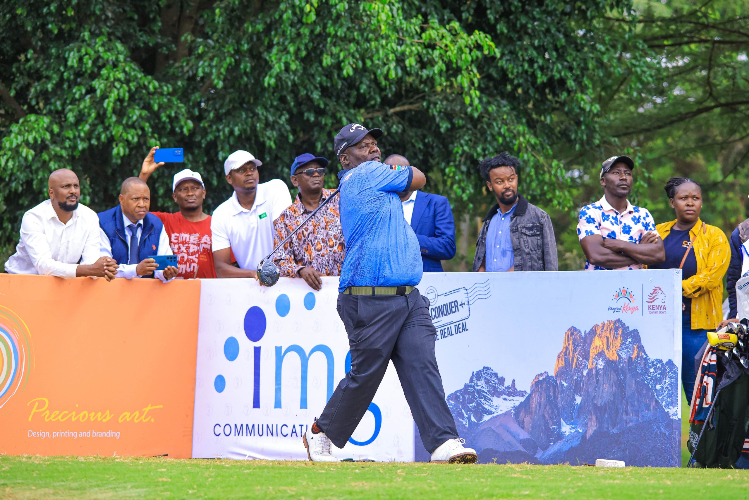Veteran golfer Dismas Indiza teeing off surrounded by spectators during the Sunshine Development Tour at Ruiru Sports Club.